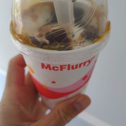 a hand holding a cup of ice cream