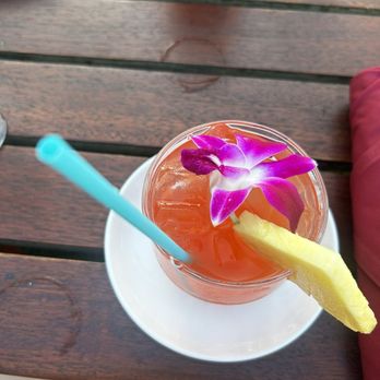 Old Lahaina Luau - non-alcoholic beverage, fruit punch with a flower and a slice of fresh pineapple. - Performing Arts Near Me - Lahaina, Hawaii