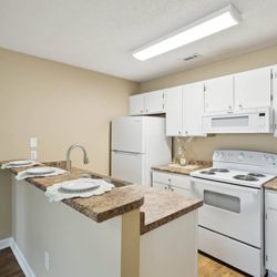 Seasons Apartments - A kitchen with white appliances and a granite counter