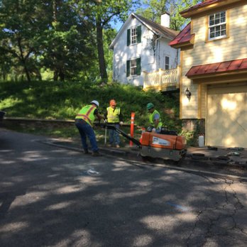 Koppers Quality Waterproofing - Walk-behind roller levels city street to prevent driveway water damage. - Waterproofing Near Me - Bowie, Maryland