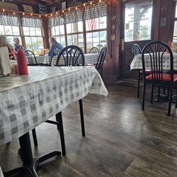 Justin's Place - Front entrance and dining area. There are 9 square tables.