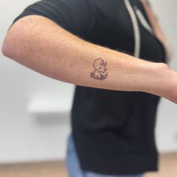 Finer Things Tattoo - Arm with cartoon dinosaur tattooed on it - Tattoo Near Me - Seattle, Washington Finer Things Tattoo - Arm with cartoon dinosaur tattooed on it - Tattoo Near Me - Seattle, Washington