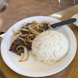 Stake with onions on top, side rice