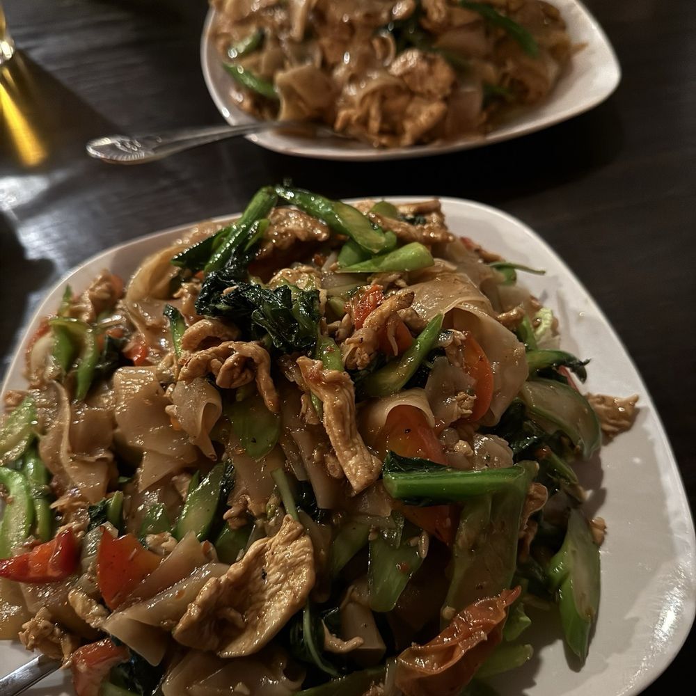 Closest one is Pad Kee Mao added Chinese's broccoli and the across is Pad See Ew Closest one is Pad Kee Mao added Chinese's broccoli and the across is Pad See Ew