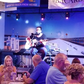 Scotty's Front Street Stage - a man playing a guitar - Seafood Near Me - Key West, Florida Scotty's Front Street Stage - a man playing a guitar - Seafood Near Me - Key West, Florida