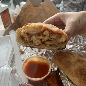 AJ's Pizzeria & Restaurant - a hand holding a sandwich - Pizza Near Me - Brooklyn, New York
