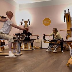 Movement For Everyone - Instructor providing hands-on cuing during Gyrotonic Pulley Tower group class.