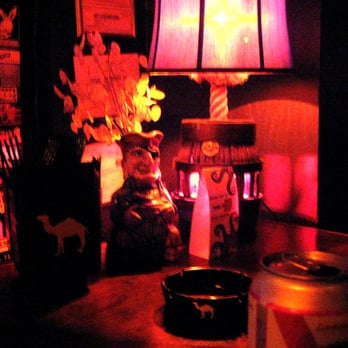 Snug Harbor - a table with a candle and a lamp - Bars Near Me - Charlotte, North Carolina