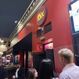 a group of people standing outside of a restaurant a group of people standing outside of a restaurant