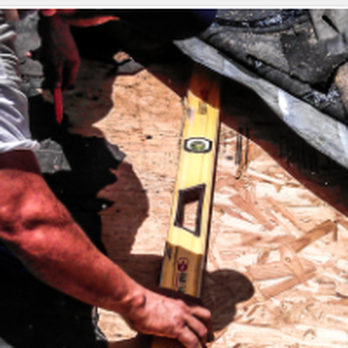 USLegacy - a man measuring a piece of wood - General Contractors Near Me - Houston, Texas