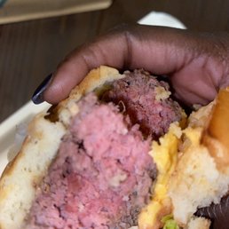 a hand holding a hamburger a hand holding a hamburger