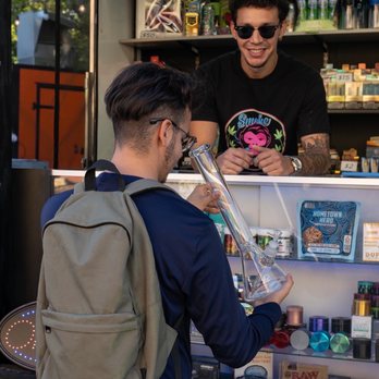 Smoke Paradise - Customer looking at water pipe - Tobacco Shops Near Me - Austin, Texas Smoke Paradise - Customer looking at water pipe - Tobacco Shops Near Me - Austin, Texas