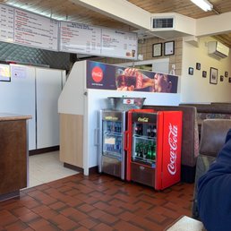 a man sitting at a table with a soda machine