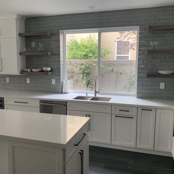 Exquisite Remodels - Our new kitchen with floating shelves and wall-to-wall back splash. - General Contractors Near Me
