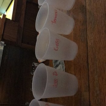 Thirsty's - a row of empty plastic cups on a wooden table - Dive Bars Near Me - Pittsford, New York