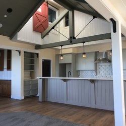 Steve McKee Architect - An upstairs office overlooks the kitchen below. Privacy is achieved with the barn door painted "Maybeck Red."