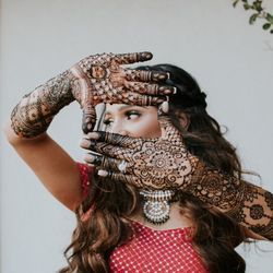Hokulani Henna - Indian bride frames her eyes with hands adorned by intricately filled mehndi designs.