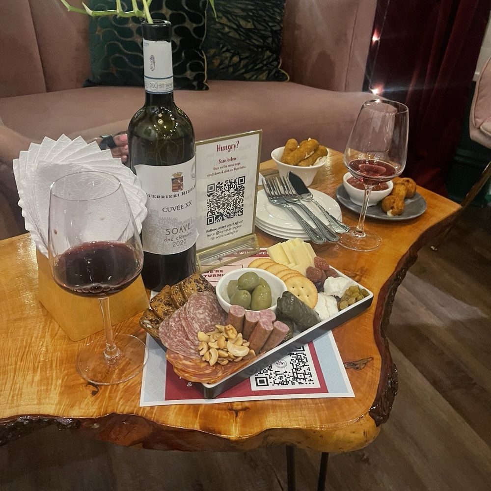 Charcuterie board with mozzarella sticks and macaroni bites also had a glass of wine. Charcuterie board with mozzarella sticks and macaroni bites also had a glass of wine.