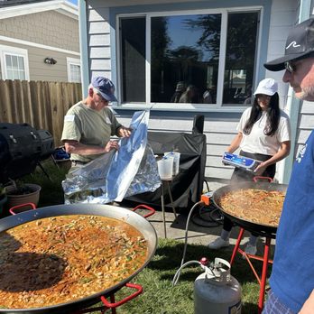 Paella Experience - The team cooking the chicken and vegan paellas. - Caterers Near Me Paella Experience - The team cooking the chicken and vegan paellas. - Caterers Near Me