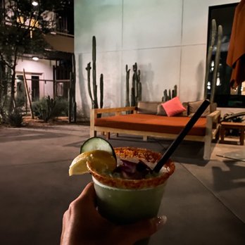 Elixir Pool Bar & Grill - a person holding a drink - Cocktail Bars Near Me - Palm Springs, California