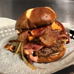 Off The Rails Burger Bar - BYOB on a pretzel bun with grilled onions.