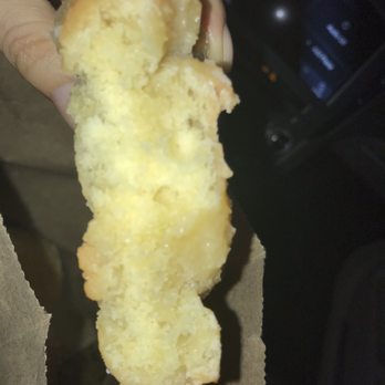 Knapp's Donuts - a hand holding a half eaten donut - Donuts Near Me - Troy, Michigan