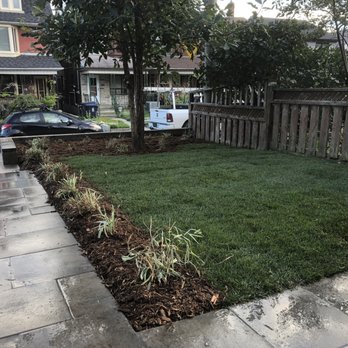 Garden SOS - a lawn with a fence and a car parked in the driveway - Gardeners Near Me - Toronto, Ontario