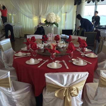 Simply Elegant - Sweetheart table backdrop in the background and chair covers in foreground - Wedding Planning Near Me