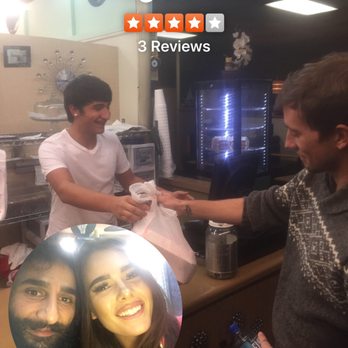Greg's Pizza - a man handing a pizza to a woman - Pizza Near Me - Grifton, North Carolina