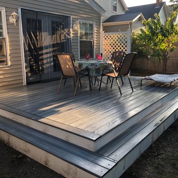 JY Construction - a deck with a table and chairs - Flooring Near Me