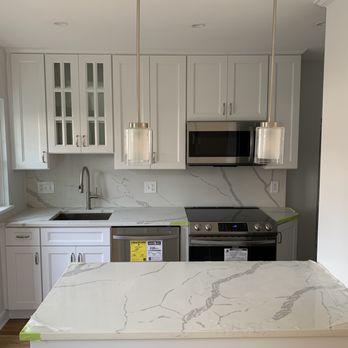 FJ Contractors - a kitchen with a marble counter top - General Contractors Near Me