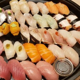 a variety of sushi on a black plate