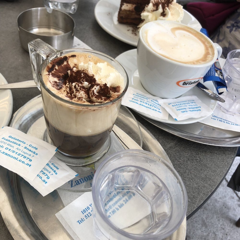 American coffee with cream in front then a cappuccino followed by the torte