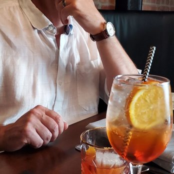 La Cucina Ristorante - a man sitting at a table with a drink - Italian Near Me - Saskatoon, Saskatchewan