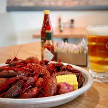 Fish City Grill - a plate of craws, corn, and a glass of beer - Seafood Near Me - Burleson, Texas Fish City Grill - a plate of craws, corn, and a glass of beer - Seafood Near Me - Burleson, Texas
