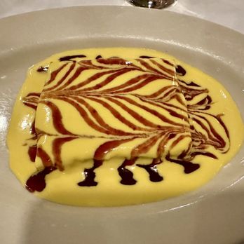 Le Rivage - Bread pudding slice with crème anglaise and raspberry sauce - French Near Me - New York, New York Le Rivage - Bread pudding slice with crème anglaise and raspberry sauce - French Near Me - New York, New York