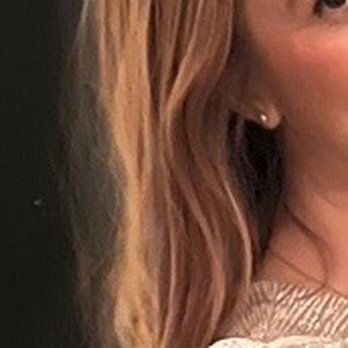 Drybar - River North - A Cosmo straight hair I'll say .Definitely I didn't want my hair to be blowout how I normally have it lol - A woman with long, wavy light brown hair wearing a light-colored top, with part of her face visible and a dark background. - Blow Dry/Out Services Near Me - Chicago, Illinois