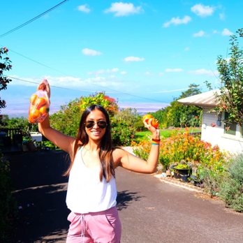 Hashimoto Persimmon Farm - My sister holding up some persimmon - Farms Near Me - Kula, Hawaii