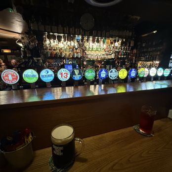 Darkey Kellys - Beers on tap. - A bar scene featuring illuminated beer taps with various brands and two drinks on the wooden counter, one dark and one red. - Pubs Near Me - Dublin, D