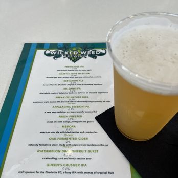Wicked Weed Brewing - a glass of beer on a table - Pubs Near Me - Charlotte, North Carolina
