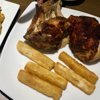 Aromas of Peru - 1/2 chicken with fried yucca and tostones on the side. Sauces not pictured but we're great for dipping - Peruvian Near Me - Wilmington, North Carolina