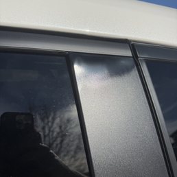 Top of driver side, rear window trim is shiny and warping at the top of the black vertical pillar panel.
