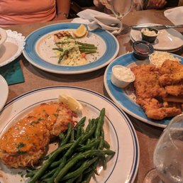 Crab cakes ( front) salmon ( back) and fish and chips on the side right