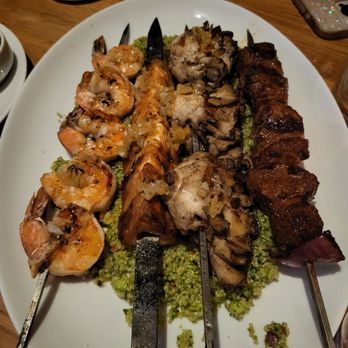 Atta Girl - (from left) grilled shrimp, fish, mushrooms, and steak skewers over herbed couscous, smoky, tender, flavorful, and perfectly shareable. - Mediterranean Near Me - Hermosa Beach, California Atta Girl - (from left) grilled shrimp, fish, mushrooms, and steak skewers over herbed couscous, smoky, tender, flavorful, and perfectly shareable. - Mediterranean Near Me - Hermosa Beach, California
