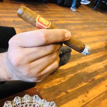 Heights Cigar Lounge - a hand holding a cigar - Tobacco Shops Near Me - Houston, Texas