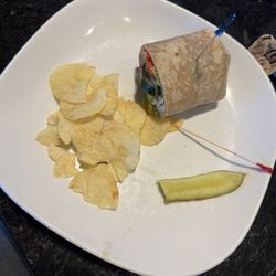 Mediterranean wrap, one half eaten. Chips and pickle were not touched, really with a half pickle??