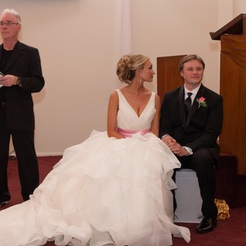 Bridal & Bridle Wedding Tailor - Bride and Groom seated while being serenaded by the choir.  The dress flows beautifully. - Sewing & Alterations Near Me