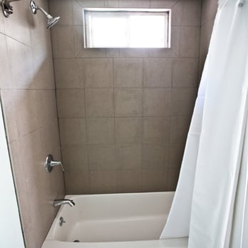 Abbey Construction - a bathroom with a bathtub and shower curtain - General Contractors Near Me - San Diego, California