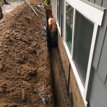 Wu Construction - The team starting their work around the perimeter of the home. You can see the water level below already. - Waterproofing Near Me - Seattle, Washington Wu Construction - The team starting their work around the perimeter of the home. You can see the water level below already. - Waterproofing Near Me - Seattle, Washington