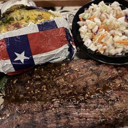 Cowboy cut steak with a baked potato and coleslaw Cowboy cut steak with a baked potato and coleslaw